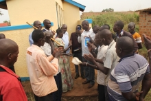 Assistant RDC Janol Okot handing over the Latrine keys to Chairperson Atek Central.